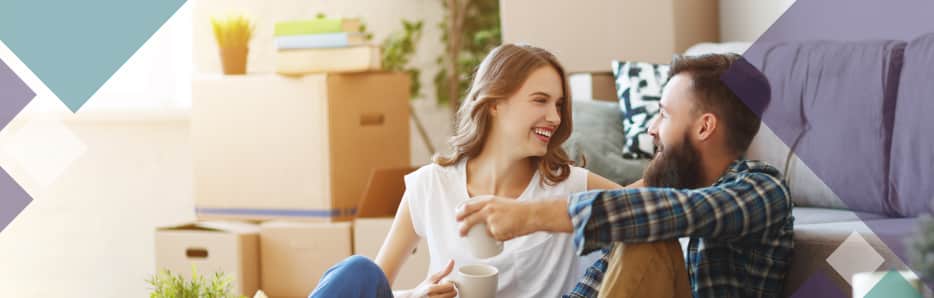 Couple sitting on floor in living room talking and smiling