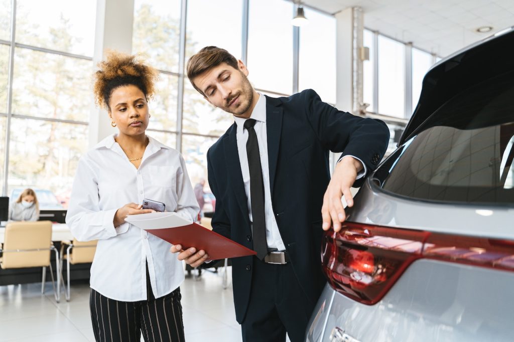 people looking at a new car