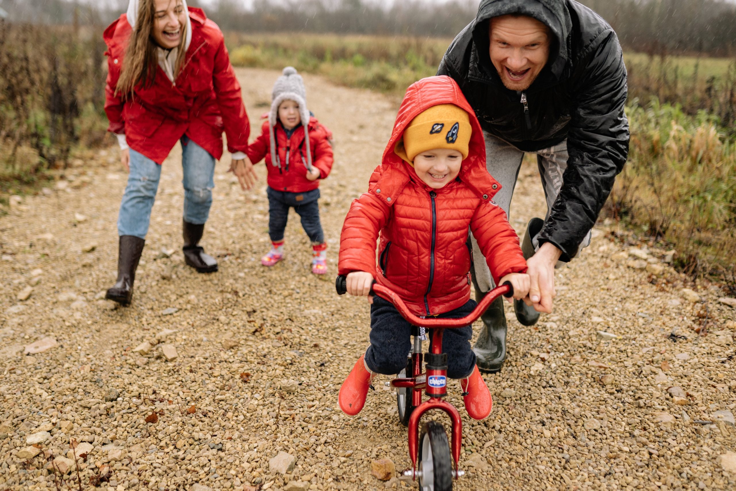 family teaching child to ride a bike